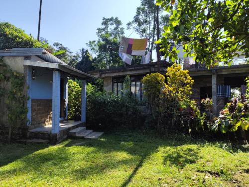 a house with a yard with grass and a building at Sylvan homestay mawlynnong in Mawlynnong
