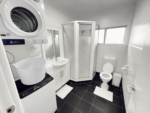 a white bathroom with a sink and a toilet at Gem 1 - Gladstone Suva CDB 2Bedroom Apartment in Suva