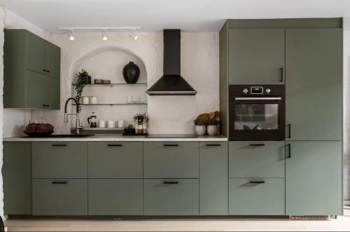 een keuken met groene kasten en een fornuis bij Tranquility near everything - Majorstua in Oslo