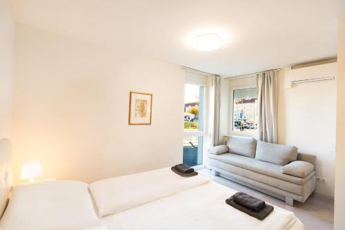 a living room with a white couch and a chair at 204 Paris 59m2 4-8 Pers extr Bedroom in Klagenfurt