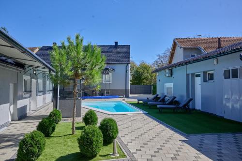 a backyard with a pool and a palm tree at Oaza Mira LAZE in Nova Gradiška