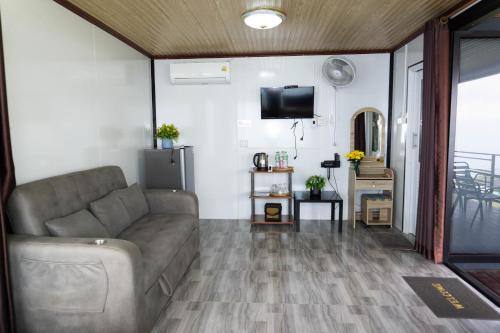 a living room with a couch and a tv at ไร่ผางาม ภูทับเบิก in Ban Maeo Thap Boek