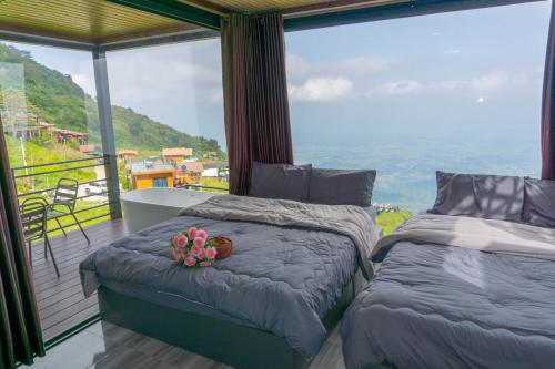 two beds in a room with a view of the ocean at ไร่ผางาม ภูทับเบิก in Ban Maeo Thap Boek