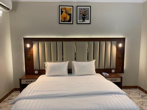 a bedroom with a large white bed with two pillows at أي رووم سويتس للشقق المخدومة in Sakakah