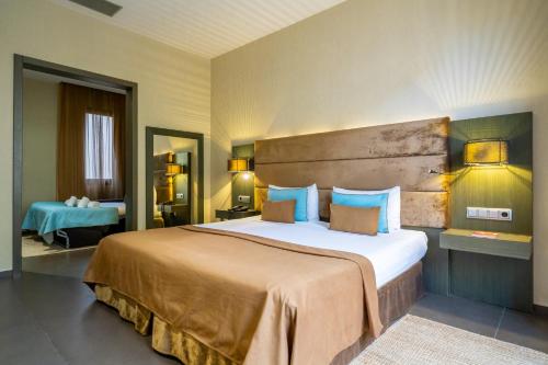 a hotel room with a large bed with blue pillows at Hotel Constanza in Barcelona