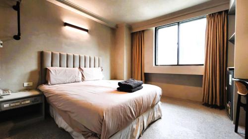 a bedroom with a large bed and a window at 艾睏設計行旅 Sleepie Design Hotel in T'ien-liao
