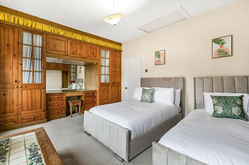 ein Schlafzimmer mit zwei Betten und einem Schreibtisch in der Unterkunft Spacious charming house near Heathrow in Feltham