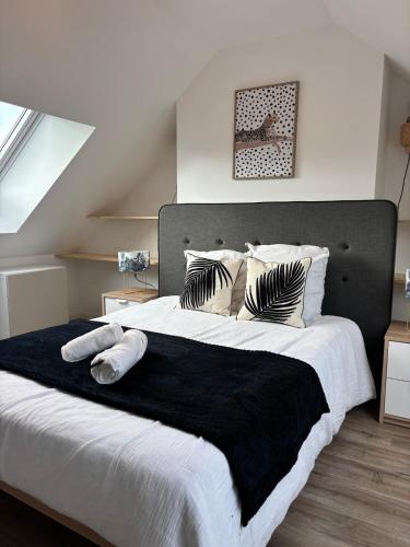 a bedroom with a large bed with black and white pillows at La Terasse de Tours in Tours