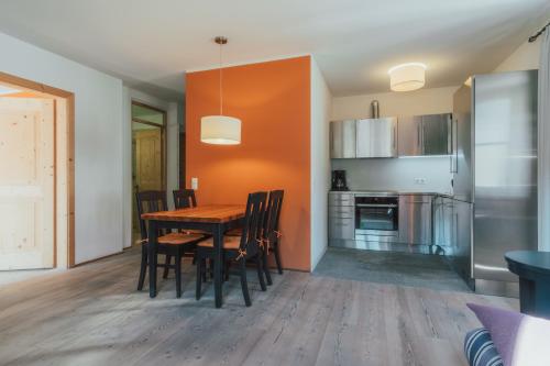 a kitchen and dining room with a wooden table and chairs at Residence Traube in Bressanone