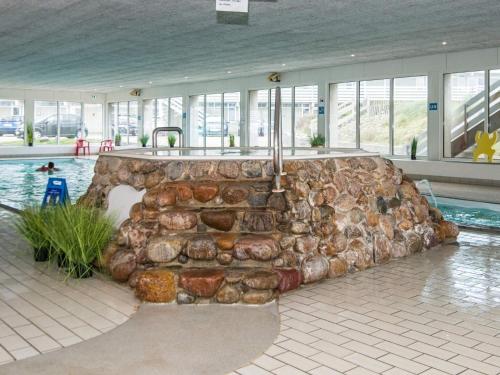 a swimming pool with a couch in the middle of a building at Søndervig Holiday Center in Ringkøbing