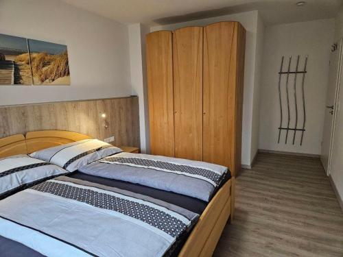 Un dormitorio con una cama y un armario de madera. en Ferienwohnung Palidi, en Ausserwald
