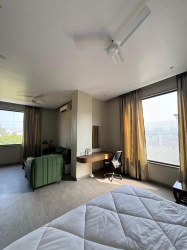 a hotel room with a bed and a desk and windows at Modern Hotel Restaurant and Bar in Mathura