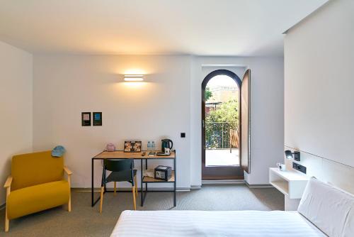 a bedroom with a bed and a desk and a chair at Hotel Melibea by gaiarooms in Salamanca