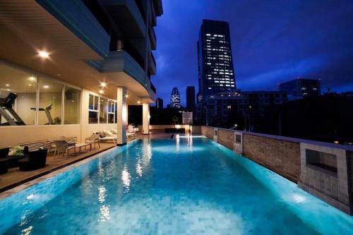 a swimming pool on top of a building at night at Bangkok Patio BTS Sanam Pao in Bangkok
