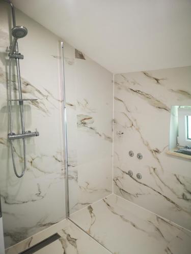 a bathroom with a shower with white marble at Haus Martha in Ilići