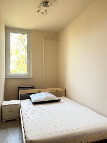 a bedroom with a bed and a window at Szántó Prime Residence in Szolnok