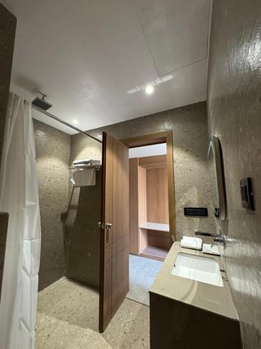 a bathroom with a sink and a shower at Modern Hotel Restaurant and Bar in Mathura