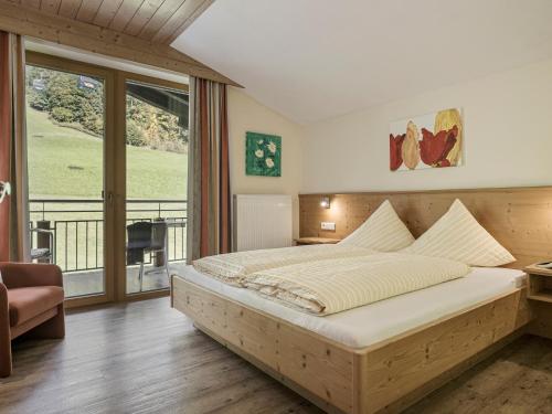 ein Schlafzimmer mit großem Bett und Balkon in der Unterkunft Appartementhaus Sennhüttn in Finkenberg