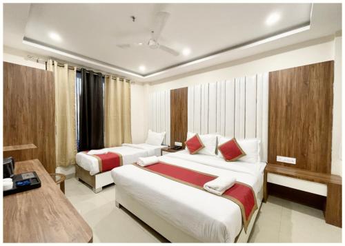 RāmnagarにあるHOTEL - SRK DIVINE Palace - Near The Holy Shree Kashi Vishwanath Temple - Free Wi-Fi & Fully Air Conditioning Hotel - Restrurant & Lift Facility - Best Hotel In Varanasiのベッド2台とテレビがあるホテルの部屋