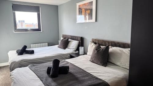 a room with two beds and a couch at Modern City Centre Apartment - 2BR - Sleeps 8 - Parking & River Views in Newcastle upon Tyne