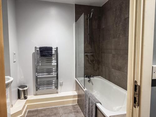 a bathroom with a bath tub and a sink at Modern City Centre Apartment - 2BR - Sleeps 8 - Parking & River Views in Newcastle upon Tyne