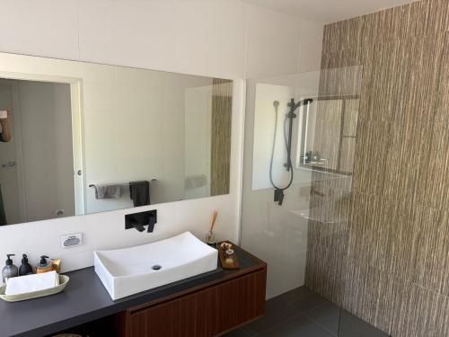 a bathroom with a white sink and a shower at Hilltop Getaway in Ocean View