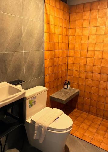 a bathroom with a toilet and a sink at Makai NAP, Thaimueang in Ban Lam Pi