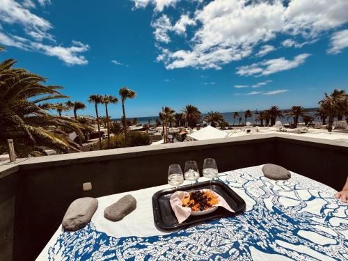 a table with a tray of food on a balcony with the beach at Casita Malvika in Costa Teguise
