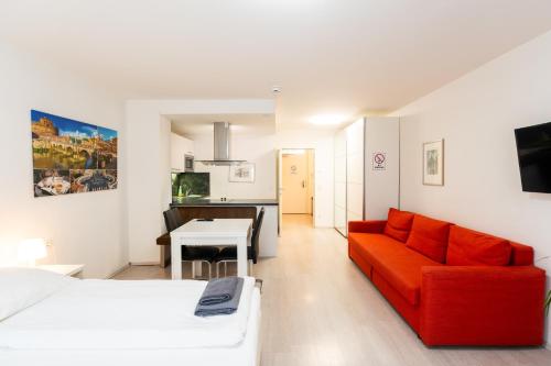 a living room with a red couch and a table at 305 Berlin, Studio Apartment, 38m2 2-4 Pers in Klagenfurt