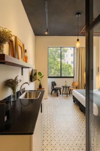 a kitchen with a sink and a bed in a room at Levinski Market Hotel in Tel Aviv