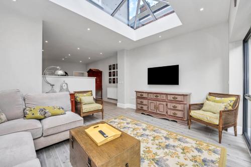 a living room with a couch and a tv at GROUND floor apartment no steps 119 Northgate St luxury 2 bedroom apartment close to the town centre with paid parking close by in Bury Saint Edmunds