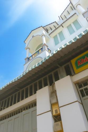 ein Gebäude mit einem Uhrenturm darauf in der Unterkunft Nguyên Thanh Hotel in Ho-Chi-Minh-Stadt