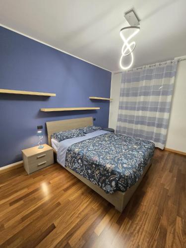 a bedroom with a bed and a blue wall at Giulia's Penthouse in Cernusco sul Naviglio