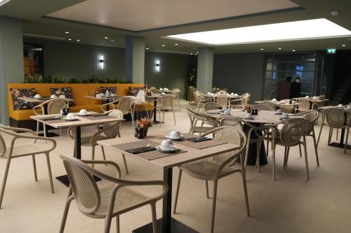 Un restaurante con mesas y sillas en una sala. en The Lince Braga, en Braga