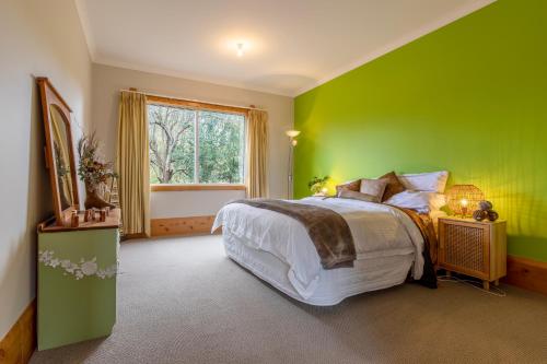 a green bedroom with a bed and a window at Hatuma Paradise in  Waipukurau