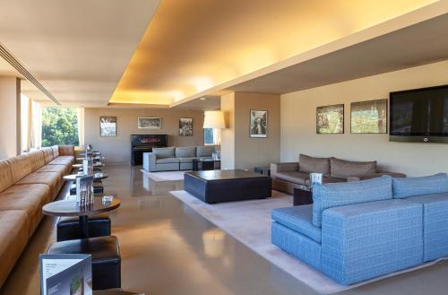 a large living room with couches and a tv at Hotel Fundador in Guimarães