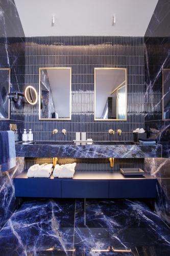 ein Badezimmer mit zwei Waschbecken und zwei Spiegeln in der Unterkunft MACAM Hotel in Lissabon