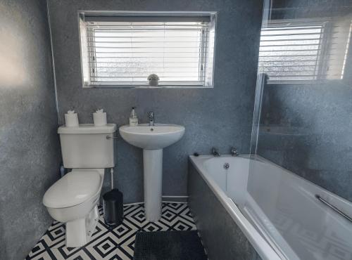 a bathroom with a toilet and a sink and a tub at Comfy 1BR Apt, Self Check In, Free Parking by The Davis Collective in Derby