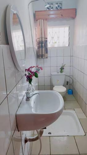 a white bathroom with a sink and a toilet at Garden House in Huye