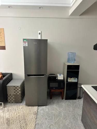 a kitchen with a refrigerator in the corner of a room at Comfort Cove - One bedroom Apartment in Kilimani, Nairobi in Nairobi