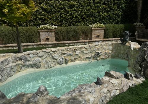 une piscine dans un mur de pierre avec de l'eau dedans dans l'établissement Domus Janas, à Scandriglia