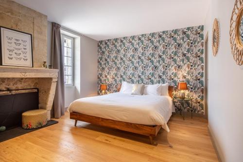a bedroom with a bed and a fireplace at Chambres d'hôtes du Château de Seguin in Lignan-de-Bordeaux