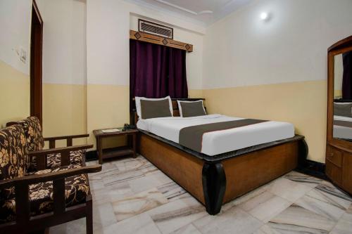 um quarto com uma cama e uma cadeira em um cômodo em Hotel New Center Point em Jaipur
