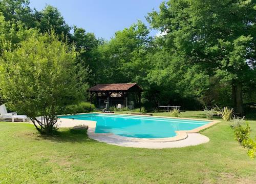 ein Swimmingpool in einem Hof mit einem Pavillon in der Unterkunft Le Gite D'origne in Origne