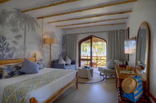 une chambre avec un lit et un bureau dans une pièce dans l'établissement Bluebay Beach Resort & Spa, à Kiwengwa