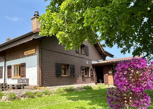 a house with purple flowers in front of it at Le Refuge du Trappeur in Crémines