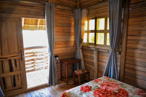 a bedroom with a bed and a door with a window at Rustic cabin in Masaka