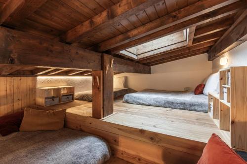 two beds in a room with wooden floors at Les Chaumes - T3 moderne piscine in Cordon