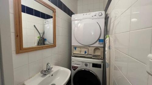 een badkamer met wastafel en wasmachine bij Joli duplex 5 pers avec piscine - Cap Ferret in Lège-Cap-Ferret