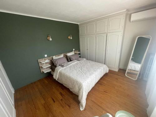 a bedroom with a bed and a green wall at Comme à la maison B and B in Carcassonne
